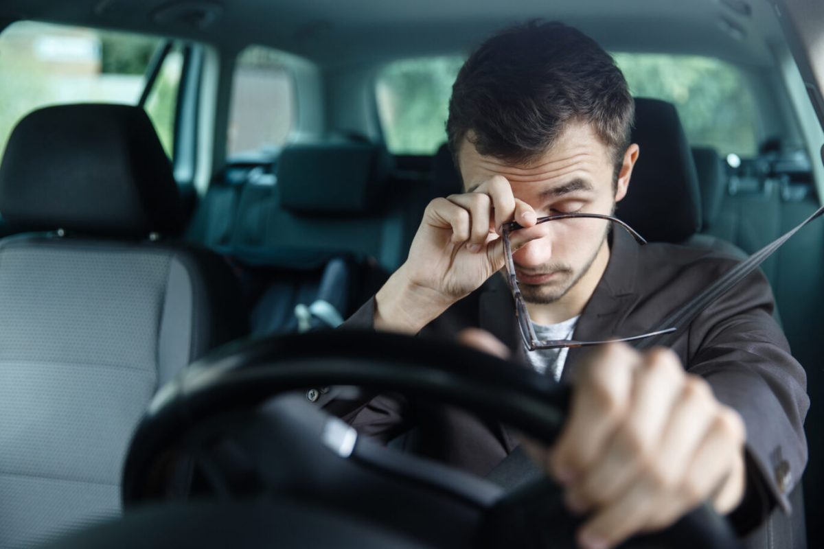 Tired male driver rubbing his eyes