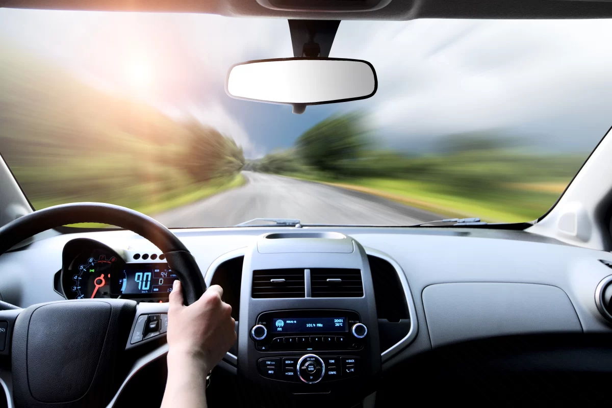 First person of the drivers hands on the steering wheel illustrating a vehicle takeover context