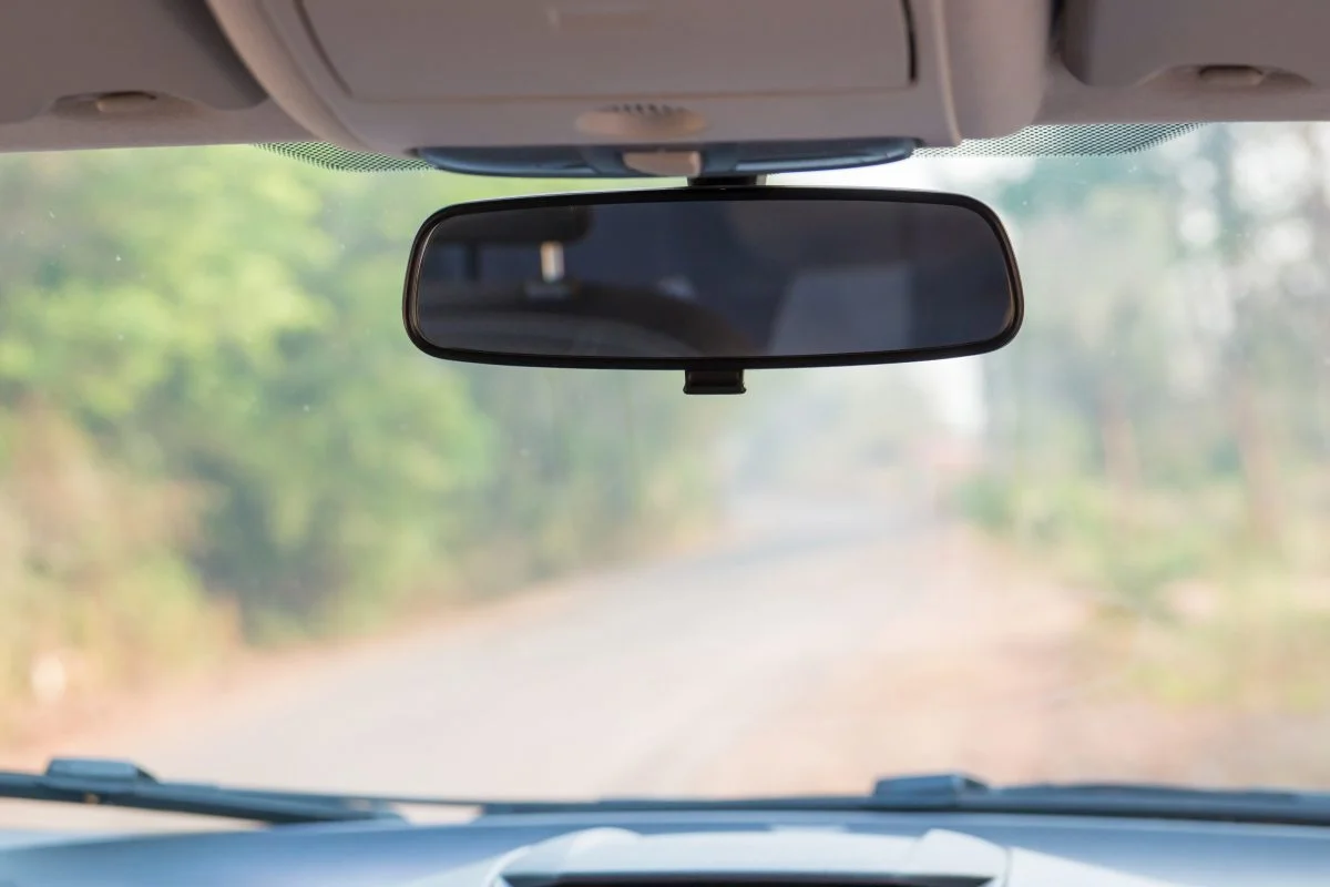 Occupant monitoring through rear-view mirror-mounted camera