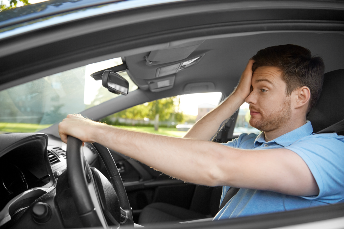 Tired male driver showing signs of driver fatigue